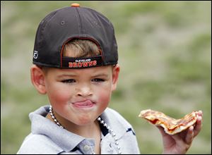 Triston Acevedo, 6, digs into Original Gino s Pizza at tastetoledo in Promenade Park yesterday.