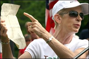 Gun activist Carol Greenberg holds a copy of the Constitution while addressing the rally.