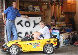 Zach McGuire, 11, is selling his toys to help his dad, Tom McGuire, left, a contractor who has been out of work since December.