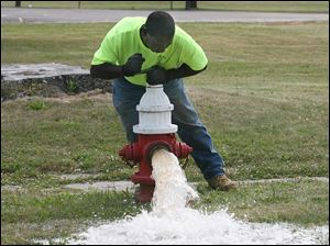 Inspector Robert Townsend checks a hydrant at the corner of Woodruff Avenue and Warren Street for water flow.