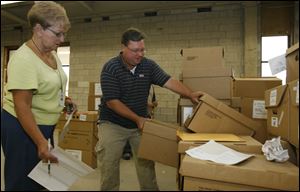 Linda Howe, director of the elections board, and Jeremy Demagall, deputy director, pull out boxes of records for review by associates of Lucas County GOP Chairman Jon Stainbrook.