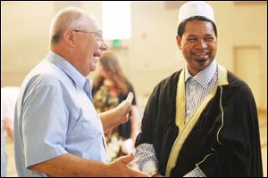 Larry Short, left, of Wauseon, shares a laugh with Imam Salie.