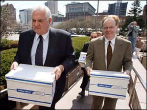 Tom Schlachter, left, and Andy Stuart of Take Back Toledo carry boxes with about 40,000 signatures to recall mayor Carty Finkbeiner into Government Center in April.