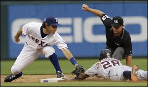 Rangers second baseman Ian Kinsler tags out the Tigers' Curtis Granderson, who was trying to stretch a single into a double in the third inning. Granderson had three hits including a homer.