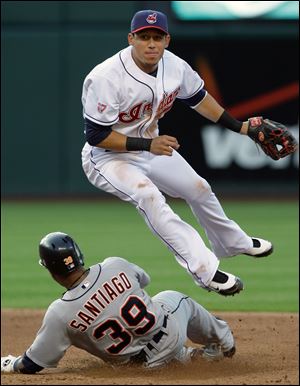 Cleveland s Asdrubal Cabrera jumps to avoid a slide by Detroit s Ramon Santiago Friday night.