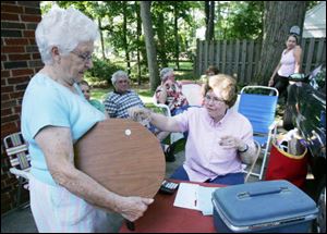 Margaret Trowbridge, left, pays Judy Dilworth for an item at Mrs. Dilworth's sale.