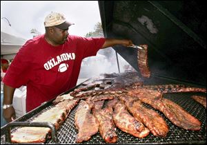 Gregory Meredith grills ribs for his Po Mo's Ribs of Toledo booth at the Smoke on the Water rib festival at Promenade Park. Proceeds benefit the local chapter of the American Red Cross. 