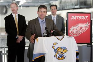 Nick Vitucci, center, talks about the affiliation agreement as Jim Nill, of the Red Wings, left, and Joe Napoli of the Walleye stand by at the Lucas County Arena.