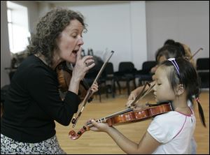 Cheryl Trace instructs Sara Lee to play a section of a piece more quietly. Ms. Trace teaches the violin and viola according to the Suzuki method for the Toledo Symphony School of Music. 