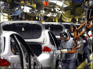 Ford workers assemble the 2008 Focus in Wayne, Mich., where Saturday shifts and overtime are being added this summer.