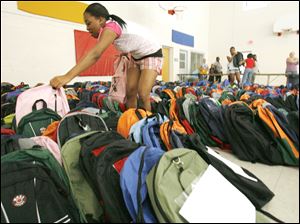 Slug: REL BACKPACKS20p          Date 8/20/2009           The Blade/ Amy E. Voigt           Location: Toledo, Ohio  CAPTION:  Jasmine King, an employee at The Salvation Army, picks through hundreds of new backpacks to choose a pink one for a client while handing out  hundreds of backpacks and other school supplies on August 20, 2009.