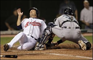 The Indians' Jamey Carroll slides across the plate before Rob Johnson can apply his tag during the fifth inning Friday night.