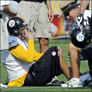 Trainers work on the foot of Ben Roethlisberger Thursday.
