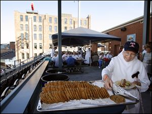 Sister Jeanne Ward adds a cookie to her plate during the cookout at Fifth Third Field.
