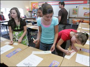 C From left: Sixth-graders Rose Younglove, Sarah Kaiser, and Abigail Fleszar choose their classroom seats during an open house of the Hollywood campus.