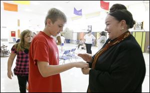 Fifth-grader Joe Sohasky touches a piece of a meteor and makes a wish as he meets children's author/illustrator Patricia Polacco, who was visiting Maplewood Elementary School in Sylvania Tuesday.