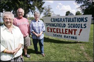 From left: Barb and Lee Irons, retired teachers from the school district, and Barbara Hartman, a retired superintendent's secretary, show off their hand-painted sign publicizing their pride.