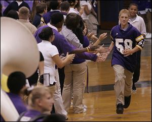 Freshman football player Tyler Ragland runs through a greeting tunnel during Waite High School's orientation.