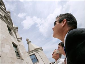 Seneca County Commissioner Ben Nutter, foreground, Steven Dobronos of Architectural Fiberglass, center, and Franklin Conaway of the Seneca County Courthouse and Downtown Redevelopment Group examine architectural pieces made of fiber glass on the Terminal Tower in Cleveland.