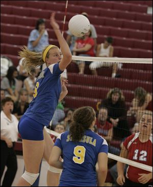Maggie Burnham, a 6-2  junior who was named All-City League first team last year, spikes the ball against Bowsher.