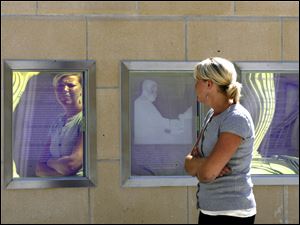 Slug: CTY tatum                   Date 9/11/2009           The Blade/ Amy E. Voigt           Location: Toledo, Ohio  CAPTION:  Kim Corcoran, who works downtown, looks at the dedication to Arthur Tatum Jr. that is near the sculpture in front of the new downtown arena on September 11, 2009.