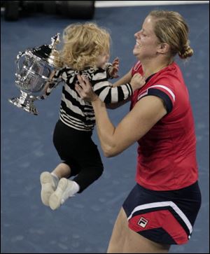 Kim Clijsters of Belgium lifts her daughter Jada after winning the women's championship over Caroline Wozniacki, of Denmark, at the U.S. Open tennis tournament in New York, Sunday, Sept. 13, 2009. 