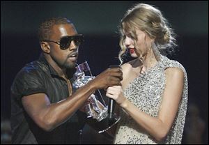 Singer Kanye West takes the microphone from singer Taylor Swift as she accepts the 