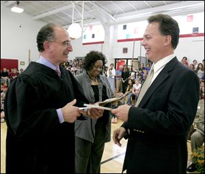 U.S. District Judge Jack Zouhary, who presided over the naturalization ceremony at McCord Junior High School, congratulates Mike Sigov, Blade reporter and columnist, on becoming a citizen.
