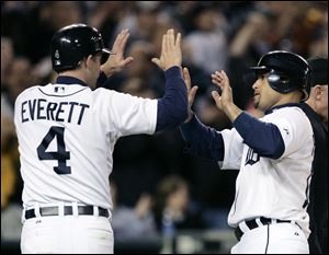 Adam Everett and Placido Polanco high-five after scoring on a double by Magglio Ordonez in the third inning of Game 2 of the Tigers' doubleheader against the Twins.