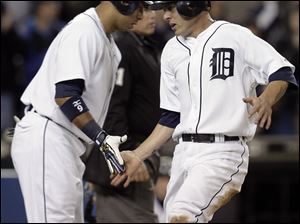 Carlos Guillen, left, greets Brandon Inge after Inge scored on a two-run single by Ramon Santiago in the second inning. The Tigers can clinch the AL Central Division with a victory today.