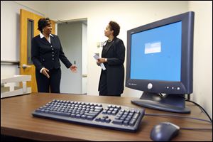 Shanda Gore, right, vice president of the Office of Equity and Diversity at the University of Toledo, shows Oona Temple her new office at the opening yesterday of the minority business incubator on the UT Scott Park campus. Ms. Temple is the owner of Cosine Technical Group LLC, a technical staffing agency.