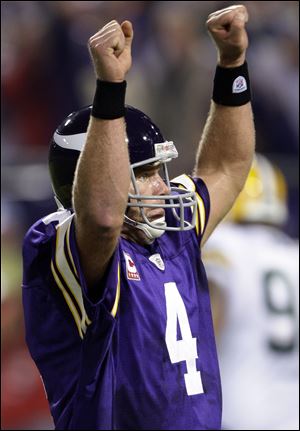 Vikings quarterback Brett Favre celebrates a touchdown last night against Green Bay. Favre completed 24 of 31 passes for 271 yards.