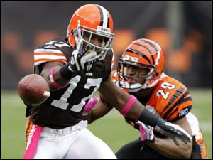 Former Browns wide receiver Braylon Edwards drops a pass while defended by Bengals cornerback Leon Hall on Sunday. Edwards' legacy in Cleveland was marred by dropped passes and off-the-field incidents.