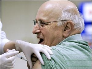 Bob Conklin of Grand Rapids, Ohio, gets his shot. More than 1,100 people received shots at yesterday's clinic, which was intended to provide vaccines and information to the public, as well as to test the health department's ability to vaccinate a large number of people in a day.