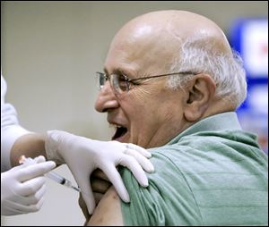 Bob Conklin of Grand Rapids, Ohio, gets his shot. More than 1,100 people received shots at yesterday's clinic, which was intended to provide vaccines and information to the public, as well as to test the health department's ability to vaccinate a large number of people in a day.