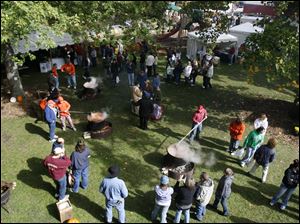 Slug: CTY festival12p                           Date 10/11/2009           The Blade/ Amy E. Voigt                   Location: Grand Rapids, Ohio  CAPTION: Three cauldrons of apple butter are being stirred during the annual Apple Butter Festival in downtown Grand Rapids, Ohio. on October 11, 2009.
