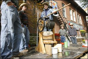 Slug: CTY festival12p                           Date 10/11/2009           The Blade/ Amy E. Voigt                   Location: Grand Rapids, Ohio  CAPTION: From left: Tom Wilson, Ryan Johnson, Jay Gallagher, Josh Main, and Ben Feather, use an apple press to make cider during the annual Apple Butter Festival in downtown Grand Rapids, Ohio. on October 11, 2009.