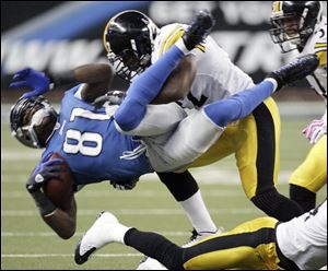 Detroit's Calvin Johnson is tackled by James Harrison. Johnson left the game in the first quarter with an injured knee.
