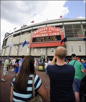 In this July 6, 2009, file photo showing fans arriving for a baseball game between the Atlanta Braves and the Chicago Cubs at Wrigley Field in Chicago. The Cubs filed for bankruptcy in Delaware on Monday, Oct. 12, 2009. The move was anticipated as the Tribune Co. looks to complete an $845 million sale of the team, Wrigley Field and related properties to the family of billionaire Joe Ricketts.