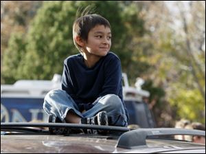 Six-year-old Falcon Heene sits cross-legged on the roof of his family's van outside his home in Fort Collins, Colo., after he was found hiding in a box in a space above the garage Thursday.