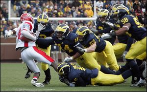 Michigan's defense swarms Justin Wilson. The Hornets did not get a first down until their sixth drive.