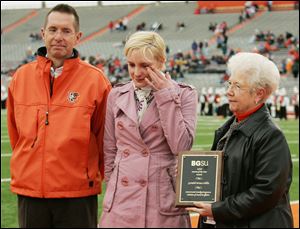 Amanda Hills accepts the award for her grandfather, Gerald Bruce Hills, held by BGSU President Carol Cartwright. Also at Saturday's ceremony was Ed Whipple, student affairs vice president. Gerald Bruce Hills raised granddaughter Amanda Hills, 23, from a young age to believe in education's importance.