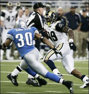 The Rams' Steven Jackson avoids umpire Bill Schuster while being pursued by Lions safety Ko
Simpson on a 25-yard touchdown run in the fourth quarter that sealed the win for St. Louis.