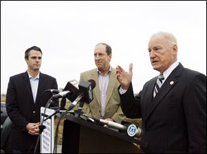 Eric Schippers, left, and Tim Wilmott of Penn National Gaming join Mayor Carty Finkbeiner at the East Toledo site where Penn National will build and operate a voter-approved casino.
