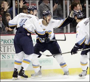 Jonathan Carlsson, left, Evan Rankin and Jean-Claude Sawyer celebrate Rankin's game-winning goal in overtime against Kalamazoo at Lucas County Arena. 
