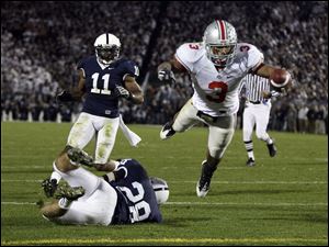 Ohio State's Brandon Saine dives into the end zone for a score after catching a pass from Terrelle Pryor and breaking an attempted tackle by Penn State's Drew Astorino (28) in the second half.
