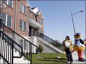 Slug:CTY tour08p                         Date 11/7/2009           The Blade/ Amy E. Voigt                   Location: Toledo, Ohio  CAPTION:  Ida Phenix, left, walks by Muddy to check out the facade of 1636 Dorr Street Brownstowns during the Tour Toledo Preview of Homes tour that was open to the public on November 7, 2009.