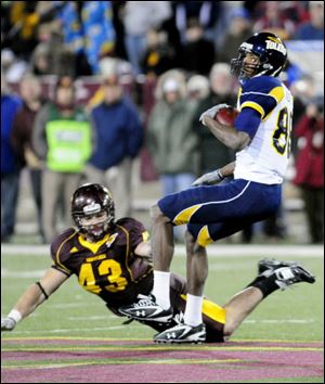 Toledo's Stephen Williams spins to avoid Central Michigan'sNick Bellore during a punt return in last night's game.