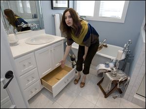 Subcontractor Amy Birdsong shows off a drawer built into the base of a vanity cabinet.