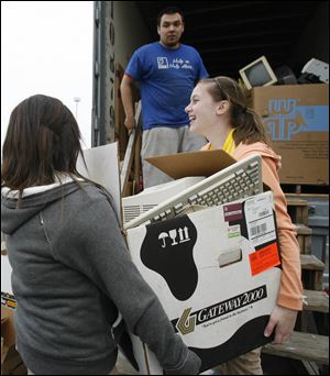 Slug:  CTY recycle16p                              Date 11/15/2009           The Blade/ Amy E. Voigt                   Location:  Toledo, Ohio  CAPTION:   Haleigh Lindner (CQ), right, reacts to how heavy the box is that she and Molly Severson, left, are trying to carry to Grant Chow, center, from Goodwill, while collecting recycles in Toledo Zoo parking lot in honor of  America Recycles Day on November 15, 2009.